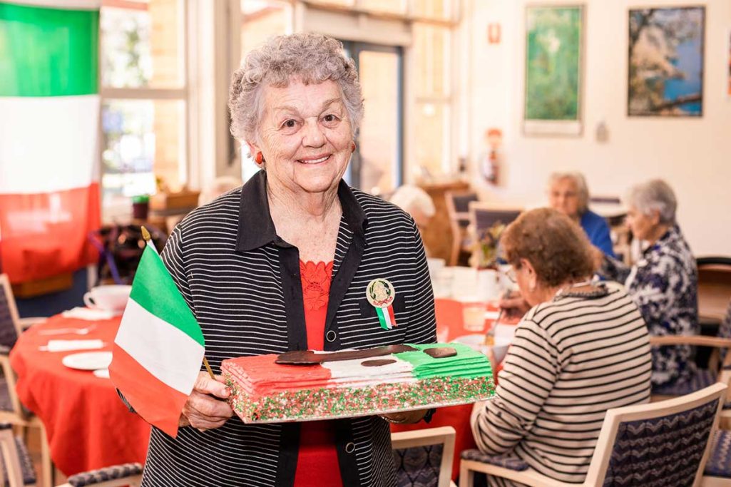 A client holding a cake that looks like the Italian Flag